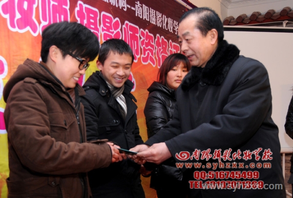 王校長為攝影班陳妍同學頒發(fā)南陽民俗攝影協(xié)會會員證 